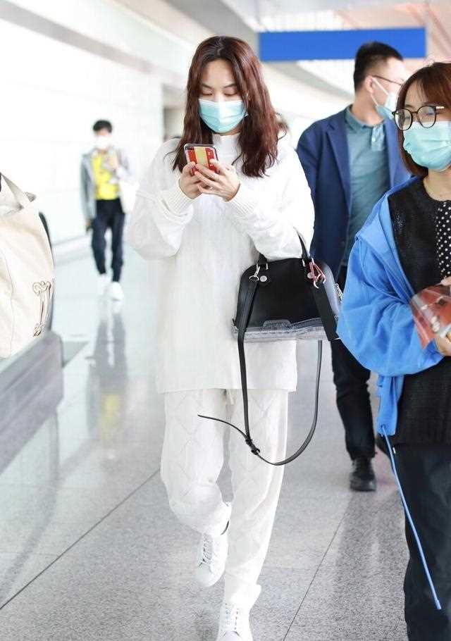 王菲菲一袭白色干净穿搭，手拿贝壳包时髦御姐